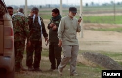 FILE - Iranian Major General Qassem Soleimani uses a walkie-talkie at the front line during offensive operations against Islamic State militants in the town of Tal Ksaiba in Salahuddin province, Iraq, March 8, 2015.