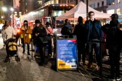 Pasien menunggu untuk menerima suntikan booster vaksin COVID-19 di stasiun vaksinasi keliling di 59th Street di bawah Central Park, di New York, 2 Desember 2021. (Foto: AP)
