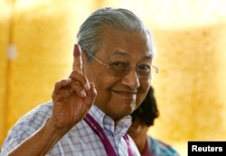 Mahathir Mohamad, mantan Perdana Menteri Malaysia dan kandidat partai oposisi Pakatan Harapan (Alliance of Hope), menunjukkan jarinya yang sudah dicelupkan tinta, tanda telah memberikan suara di TPS Alor Setar, Malaysia, 9 Mei 2018.