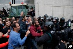 Civil guards clear people away from the entrance of a sports center, assigned to be a referendum polling station by the Catalan government in Sant Julia de Ramis, near Girona, Spain, Oct. 1, 2017.
