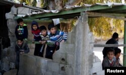 Palestinian boys watch near the a Hamas site after it was targeted in an Israeli airstrike in Gaza, March 26, 2019.