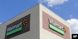 This Feb. 8, 2017, photo shows Wal-Mart signage at one of the company's neighborhood markets, in Hialeah, Florida.