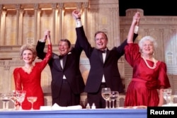 President Ronald Reagan (2nd L) and Vice President George Bush, (2nd R), accompanied by wives Nancy (L) and Barbara, join hands after the President endorses Bushes run for the Presidency