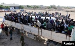 Migrants ride in a truck to a detention center in the coastal city of Sabratha, Libya, Oct. 7, 2017.
