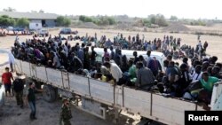 Les migrants dans un camion avant d'être transportés dans un centre de détention, dans la ville côtière de Sabratha, en Libye, le 7 octobre 2017.
