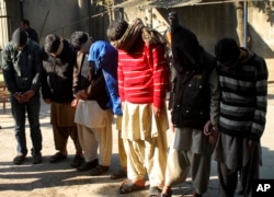 FILE - Pakistani suspects allegedly associated with the Islamic State group wait to appear in an anti-terrorism court in Gujranwala, Pakistan, Dec. 29, 2015.