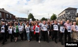 FILE - Relatives of those killed during Bloody Sunday make their way from the Bogside to the Guildhall to read the Saville report, Londonderry in Northern Ireland, June 15, 2010.