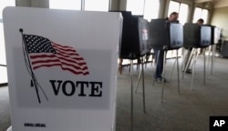 FILE - Voters cast ballots in the Illinois primary in Hinsdale, Ill., March 18, 2014. Illinois' top election officials insist that a recent hack into state voter rolls, which contain the names of 8 million active voters, does not pose a threat to the Nov. 8 election.