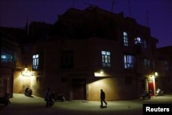 A man walks along a street at night in the old town of Kashgar, Xinjiang Uighur Autonomous Region, China, March 23, 2017. Thousands of "convenience police stations" have been built across Xinjiang. They are typically just hundreds of meters apart.