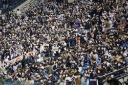 Penggemar bisbol yang telah divaksinasi penuh atau dinyatakan negatif virus dalam 48 jam terakhir atau di bawah 18 tahun, bersorak untuk tim mereka selama pertandingan bisbol wildcard pascamusim KBO antara Kiwoom Heroes dan Doosan Bears di Seoul, Korea Selatan, Senin, 1 November 2021.