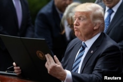 President Donald Trump prepares to sign the Executive Order on Promoting Free Speech and Religious Liberty during a National Day of Prayer event at the Rose Garden of the White House in Washington, May 4, 2017.