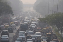 Para komuter berkendara di tengah kabut pagi dan kabut asap beracun di New Delhi, India, Rabu, 17 November 2021. (AP Photo/Manish Swarup)