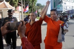 រូបឯកសារ៖ កញ្ញា សេង ធារី មេធាវីខ្មែរអាមេរិកាំង លើកដៃឡើងលើជាមួយអ្នកគាំទ្រអ្នកស្រី ខណៈអ្នកស្រីដើរនៅមុខសាលាដំបូងរាជធានីភ្នំពេញ កាលពីថ្ងៃទី ៤ ខែមករា ឆ្នាំ ២០២២។