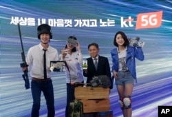Lee Pil-jae, second from right, vice president at KT Corp., and models introduce various 5G services available on smarpthones during a press conference on 5G service at KT Corp.'s headquarters in Seoul, South Korea, April 2, 2019.