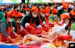 South Koreans and tourists make kimchi to donate to needy neighbors during the Seoul kimchi festival in Seoul, South Korea, Friday, Nov. 6, 2015.