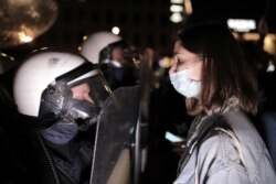Seorang perempuan berdiri di hadapan polisi saat para demonstran memblokir jalan dalam aksi protes menentang keputusan Pengadilan Konstitusional Polandia yang memperketat larangan aborsi, di Warsawa, Polandia, 26 Oktober 2020.