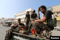 FILE - Houthi militants patrol a street where pro-Houthi protesters demonstrated against the Saudi-led coalition in Hodeida, Yemen.