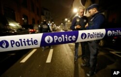 Police guard a check point during a police raid in the suburb of Schaerbeek in Brussels, March, 24, 2016.