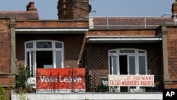 FILE - Banners of opposing views on Britain's so-called Brexit referendum on EU membership are displayed on the balconies of two neighboring apartments near London, May 27, 2016. British voters will decide on June 23 on whether to leave the bloc.