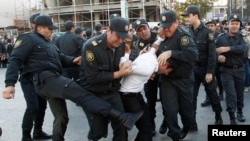Polis müxalif nümayiş iştirakçısını döyür. Bakı, 12 oktyabr, 2013.