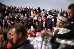 Seorang pria Muslim Bulgaria menggendong putranya di atas kuda saat mereka menghadiri ritual menjelang upacara khitanan massal di Desa Ribnovo, Bulgaria, 23 Februari 2020. (Foto: REUTERS/Stoyan Nenov)