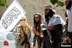 FILE - Members of the Taliban celebrate the cease-fire in Ghanikhel district of Nangarhar province, Afghanistan, June 16, 2018.