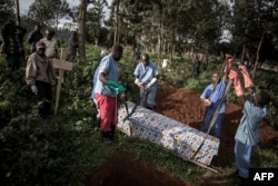 Petugas kesehatan bersiap menguburkan peti jenazah berisi pasien yang meninggal terinfeksi Ebola di Butembo, Republik Demokratik Kongo, 16 Mei 2019.