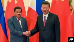 FILE - Philippine President Rodrigo Duterte, left, and Chinese President Xi Jinping pose for photographers on the sidelines of the Belt and Road Forum for International Cooperation at the Great Hall of the People in Beijing, May 15, 2017.