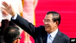 Cambodian Prime Minister Hun Sen waves to the crowd as he arrives at Clark International Airport, north of Manila, Philippines Saturday, Nov. 11, 2017.