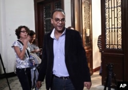 FILE - Human rights advocate Hossam Bahgat is greeted by colleagues and friends in his office at the Egyptian Initiative for Personal Rights in Garden City, Cairo, Egypt, Nov. 10, 2015.
