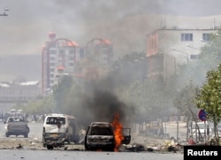 Sebuah kendaraan terbakar setelah bom bunuh diri meledak di dekat parlemen Afghanistan di Kabul, Afghanistan (22/6).
