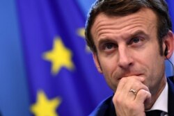 FILE - French President Emmanuel Macron looks on during a joint press conference with Germany's Chancellor Olaf Scholz (out of frame) during an European Union (EU) summit at the European Council Building at the EU headquarters in Brussels, Dec. 17, 2021
