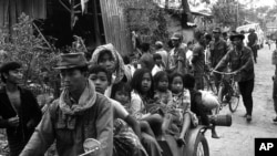 Cambodian women and children fill the back of a motorcycle taxi carrying them to safer parts of Phnom Penh as Khmer Rouge insurgents continue their artillery shellings of the capital, Jan. 28, 1974. (AP Photo)