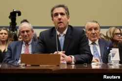 FILE - Michael Cohen, the former personal attorney of U.S. President Donald Trump, is flanked by his attorneys Lanny Davis (L) and Mike Monico (R) as he testifies before a House Committee on Oversight and Reform hearing on Capitol Hill in Washington, Feb. 27, 20