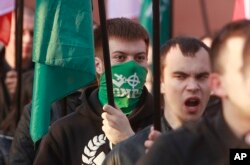 FILE - Members of nationalist organization the National-Radical Camp march through downtown Warsaw, Poland, April 29, 2017.