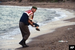 Polisi membawa tubuh seorang anak migran yang sudah tak bernyawa setelah sejumlah migran dilaporkan meninggal dan beberapa hilang akibat kapal yang mereka tumpangi ke pulau Yunani, Kos, terbalik, dekat resor Bodrum, Turki, 1 September 2015.