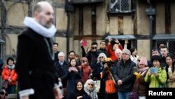 Para turis menonton pertunjukan drama oleh para seniman di sebuah rumah di mana William Shakespeare dilahirkan di Stratford-Upon-Avon, Inggris pada acara hari Sabtu (23/4).