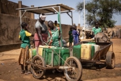 Les enfants remplissent leur bidon d'eau à la pompe à eau, dans un site qui accueille des personnes déplacées internes à Kaya, le 14 octobre 2020.