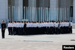 Students hold flag poles as they practice for an apparent parade to celebrate the Workers' Party of Korea (WPK) congress in central Pyongyang, North Korea, May 7, 2016.