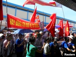 Workers wave Vietnamese national flags during an anti-China protest at a Chinese shoe factory in Vietnam's northern Thai Binh province, May 14, 2014.
