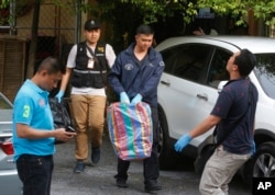 Thai policemen take evidence at an apartment on the outskirts of Bangkok on Saturday, Aug. 29, 2015.
