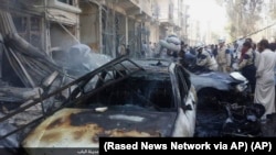 FILE - People gather around the rubble after an airstrike — believed to be Russian — in Al-Bab on the outskirts of Aleppo, Syria, Oct. 5, 2015, in a photo released by Rased News Network, which is affiliated with Islamic State militants.