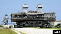A mobile launch platform is taken to the launch pad by a NASA crawler-transporter.