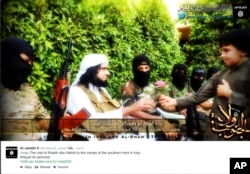 FILE - This screen grab from an Islamic State group-affiliated Twitter account, taken Sept. 20, 2014, purports to show a military commander handing a flower to a child while visiting southern Iraq. The group is a leader in using Internet-based communications.