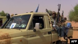 FILE - Members of an armed group sit in a vehicle in Kidal, Mali, July 13, 2016. Clashes have been reported in the restive northern city between pro-government and former rebel groups, both based there since February.