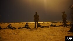 FILE - In this photo released by the U.S. Army on March 9, 2017, U.S. Army Special Forces soldiers observe as Nigerien armed forces service members fire their weapons with the assistance of illumination rounds during Exercise Flintlock 2017 in Diffa, Niger.