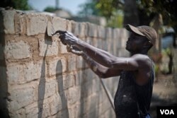 A Central African Republic man works to reconstruct a home in the PK5 neighborhood of Bangui in February 2017. (Z. Baddorf/VOA)