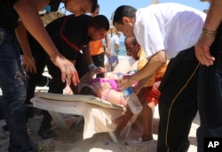 Injured people are treated after gunmen opened fire at beach near the Imperial Marhaba hotel in Sousse, Tunisia, June 26, 2015.