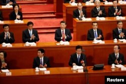 Chinese President Xi Jinping, Chinese Premier Li Keqiang and other officials applaud at the second plenary session of the National People's Congress (NPC) at the Great Hall of the People in Beijing, China March 9, 2018.