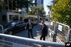 Seen behind barriers blocking the road leading to Saudi Arabia's consulate, security guards stand in Istanbul, Oct. 26, 2018.